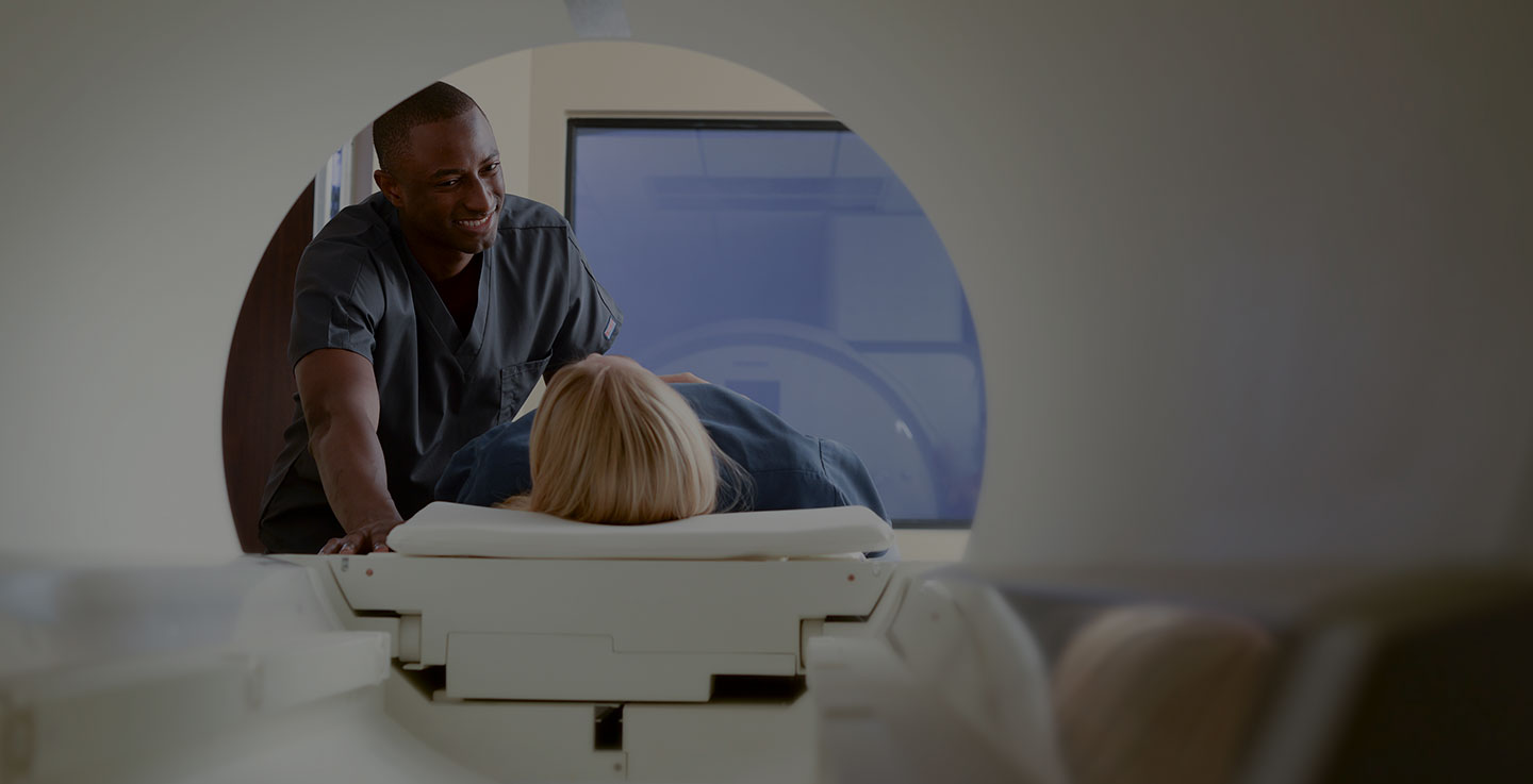 An MRI technician speaks with a patient about AdventHealth's advanced cancer imaging technology before she enters an MRI