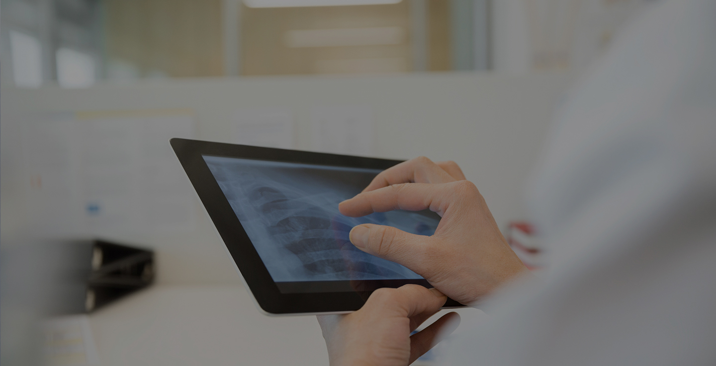 An immunotherapy specialists reviews a cancer patient's imaging scans on a tablet