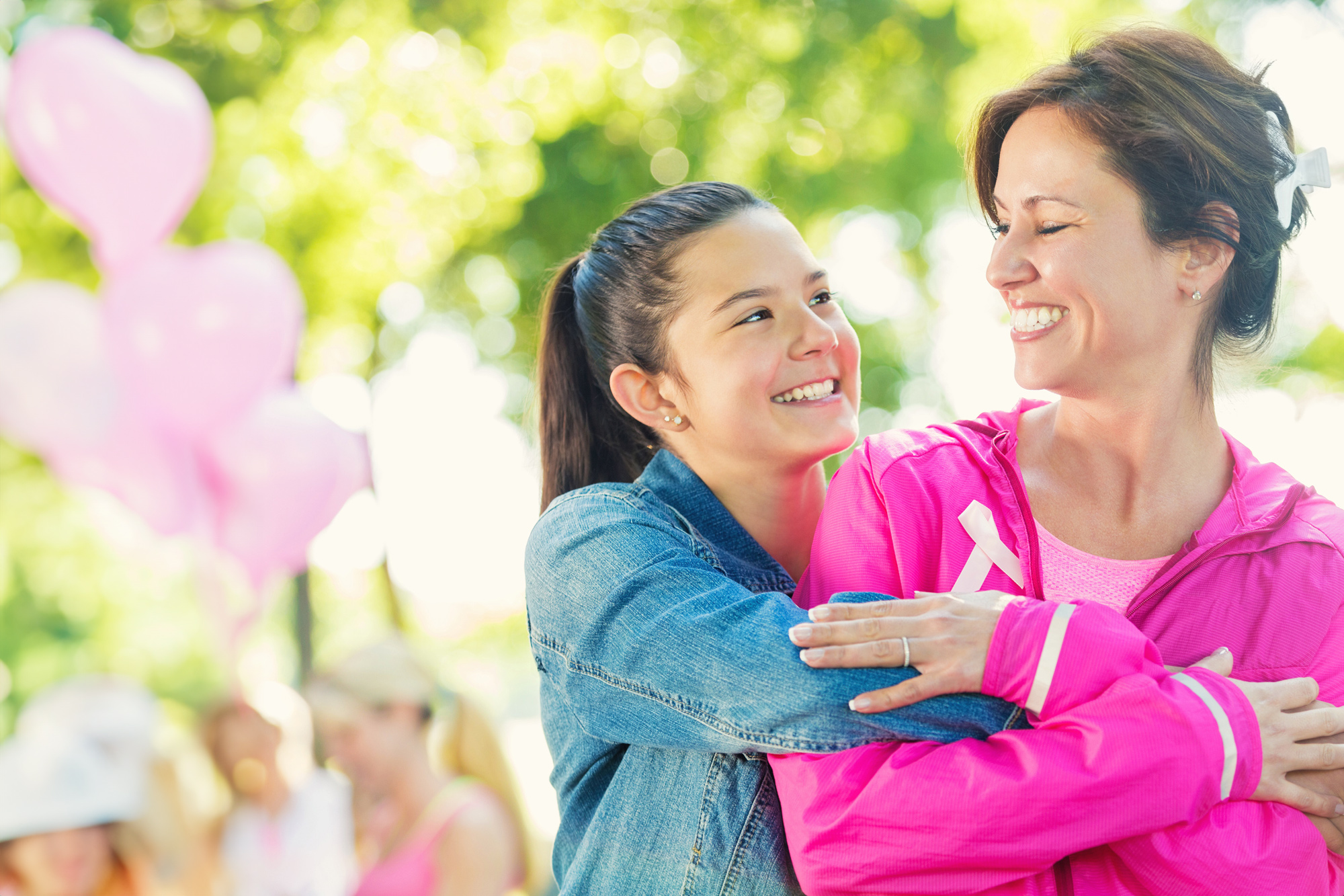 Mother and Daughter Hug at a Breast Cancer Support Event