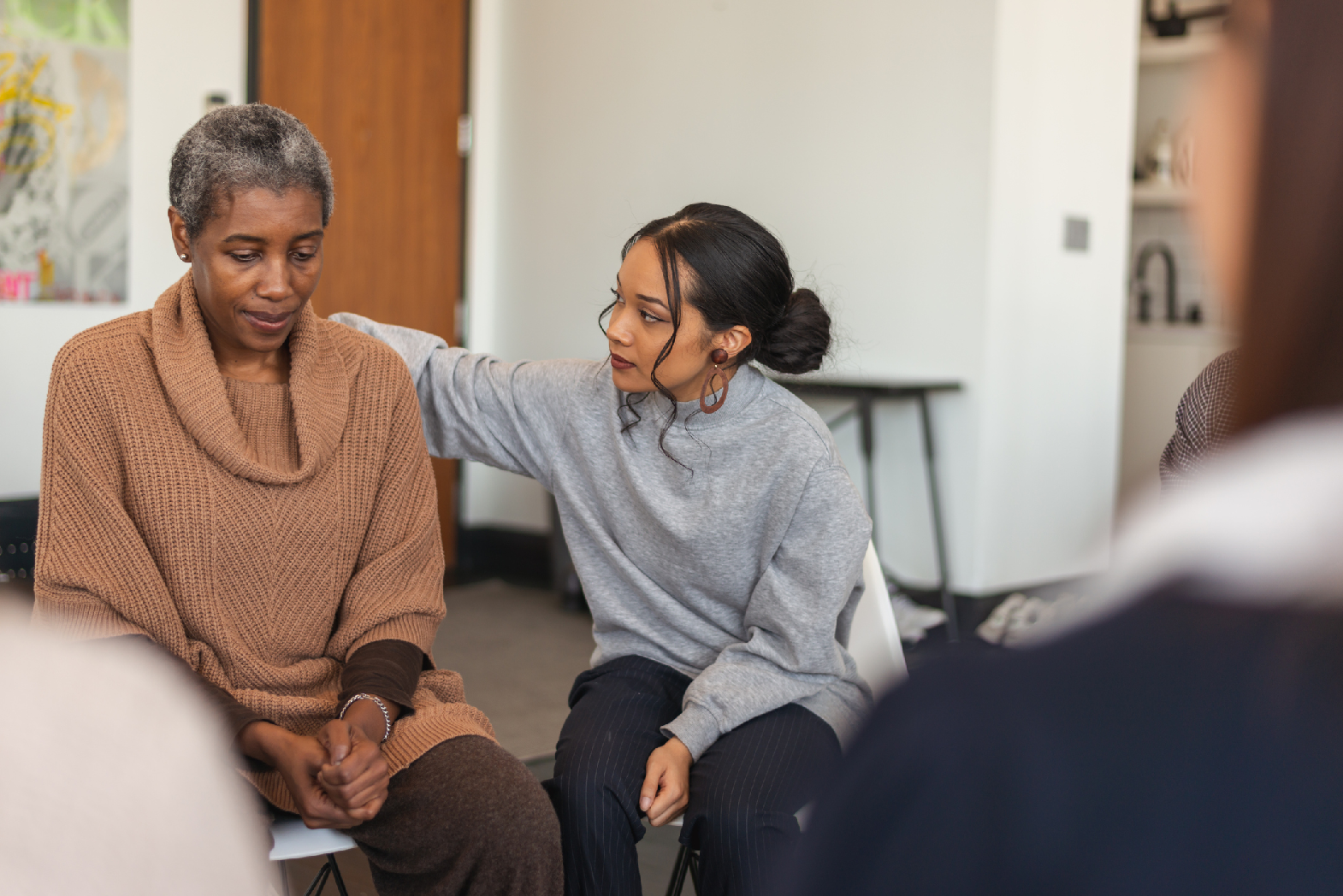 A younger woman comforts an older woman.