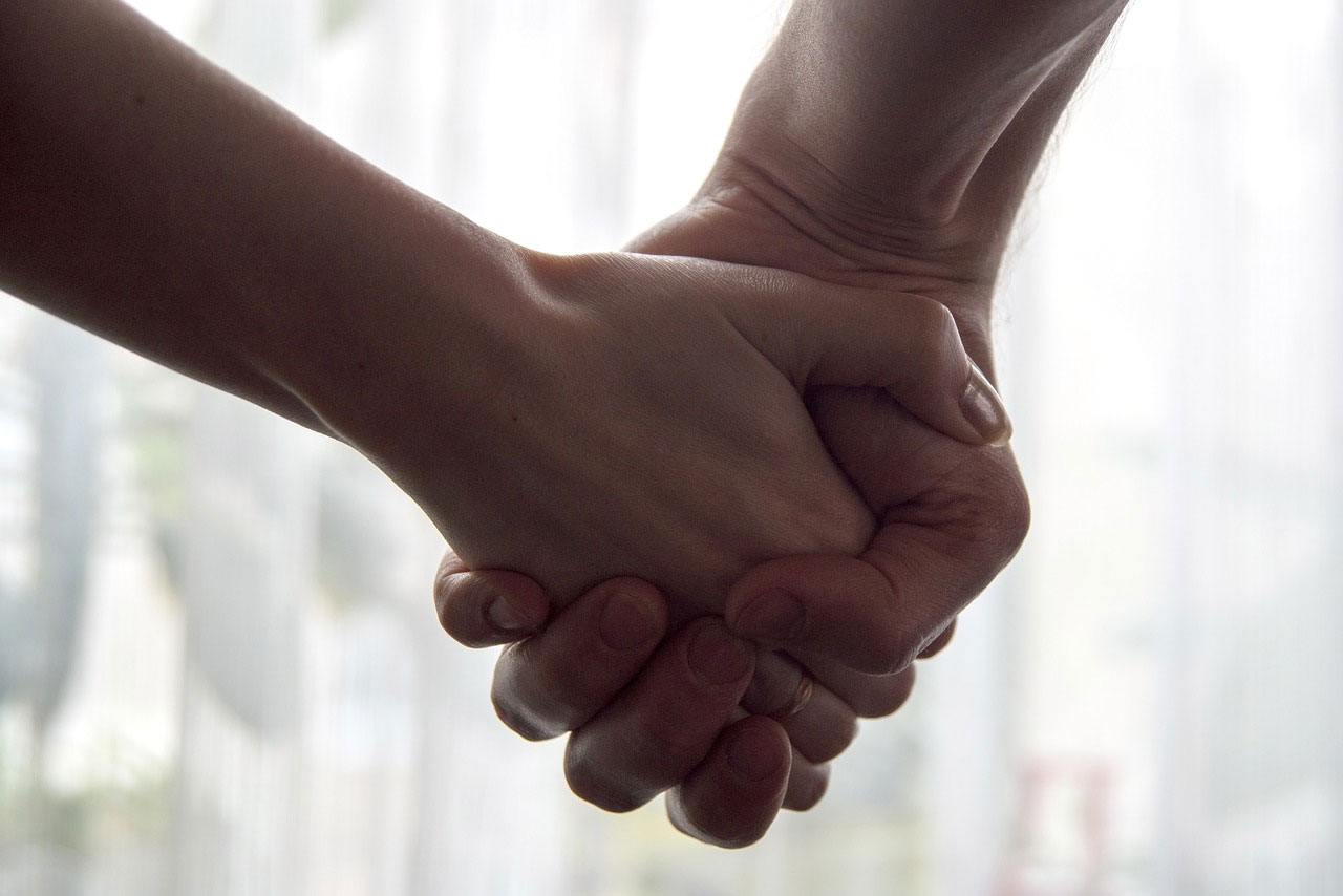 A close up image of people holding hands.