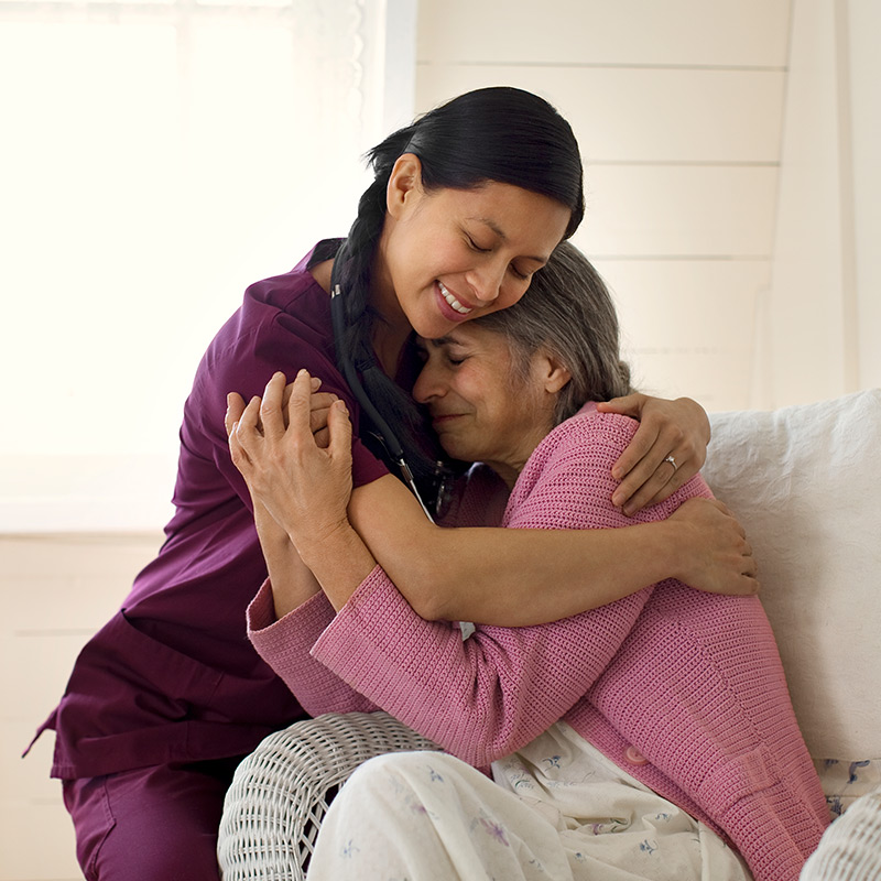 A nurse hugging her patient.